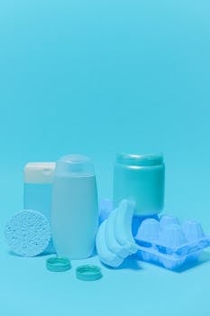 Collection of blue colored plastic containers with lids and egg tray isolated on blue background